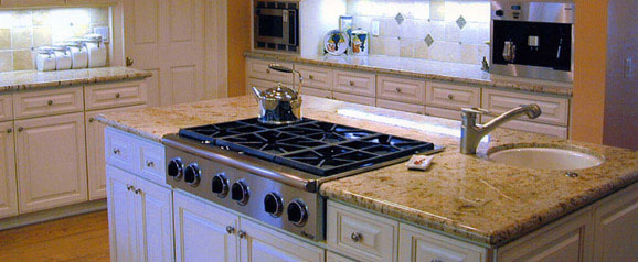 An American kitchen, with traditional style units and travertine tiles as a back splash with white bronze accent tiles to add some beautiful detail.