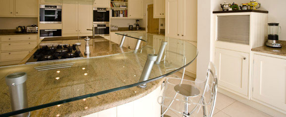 A traditional kitchen with a contemporary twist, using a glass breakfast bar, dark wood and granite worktops add a mix of texture, colour and sparkle.